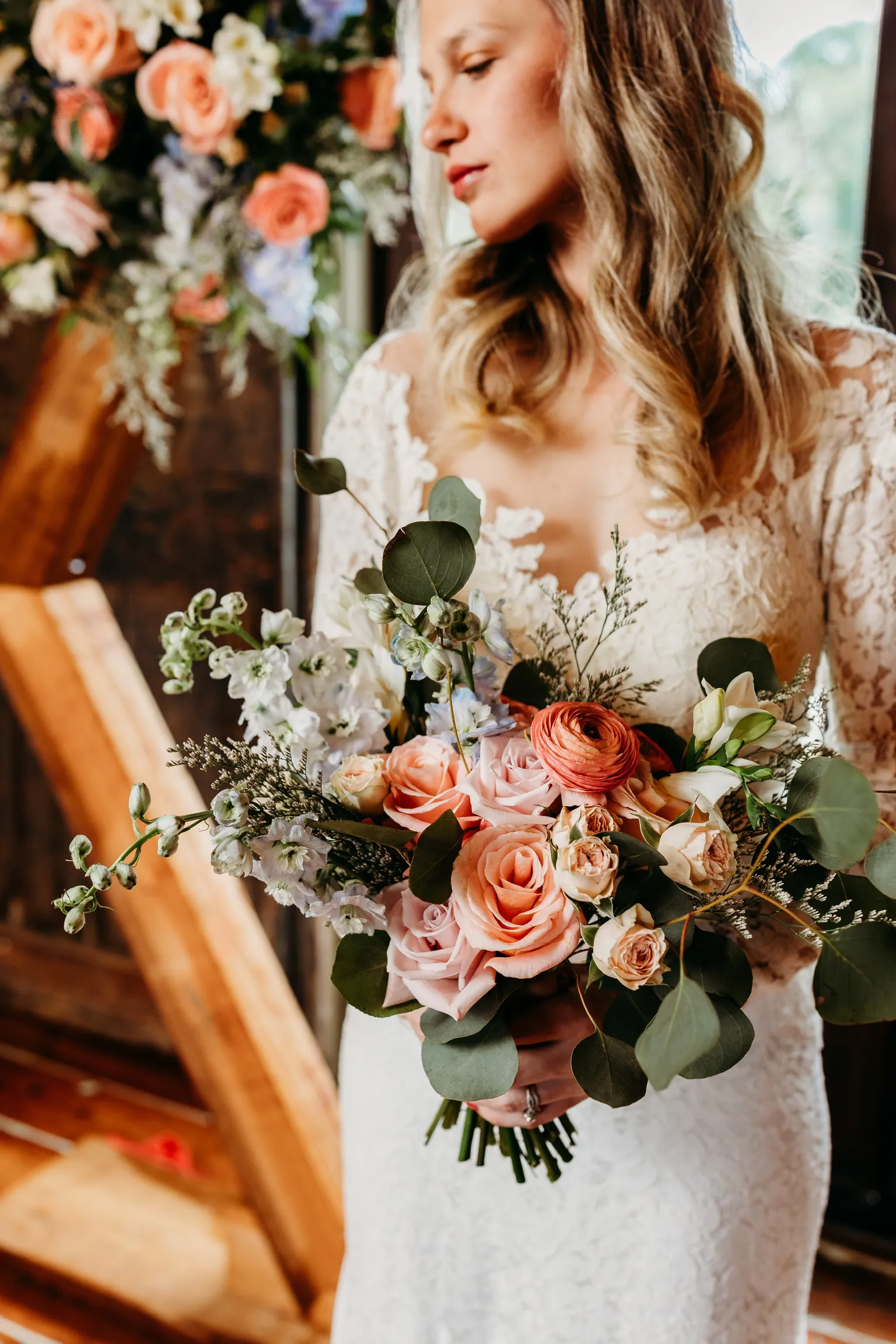 Bride holding a blush and peach garden-style bouquet
