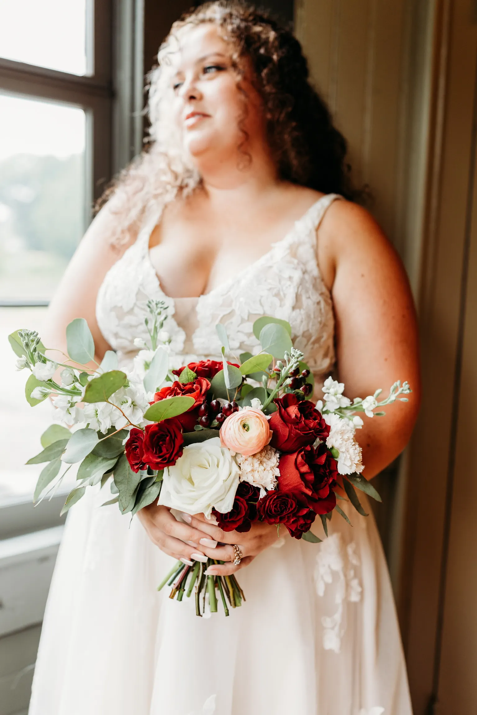 Bride holding a dark red and blush garden bouquet